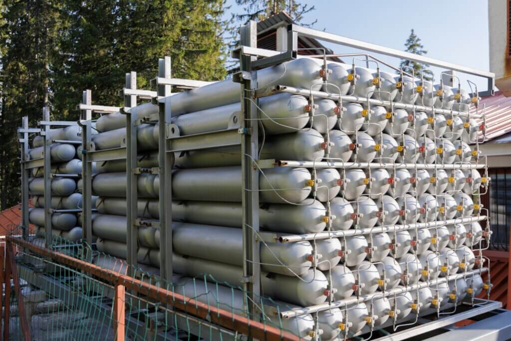 A lot of bottles filled with gas or gasoline are stacked in piles - Fuel Logic fuel delivery safety