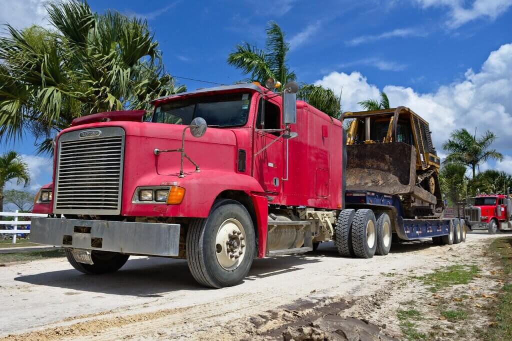 semi truck transporting a large bulldozer on a flatbed trailer